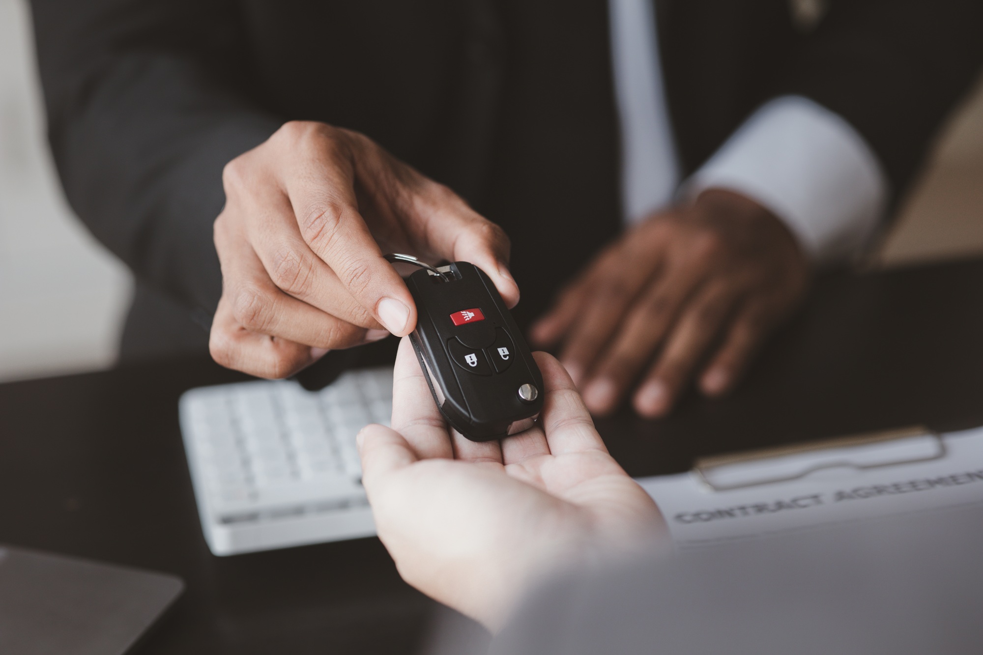 A car rental company employee pointed out the renter to sign the rental agreement after discussing t