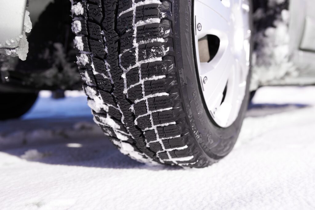 Car tires on winter snow road