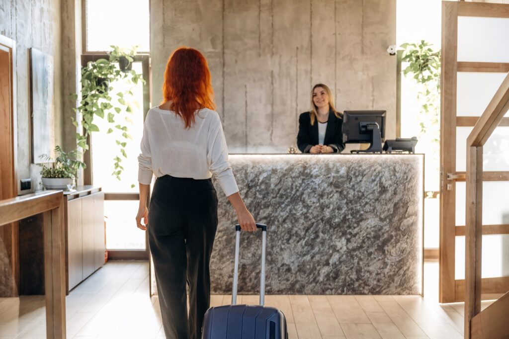 Mujer dirigiéndose a la recepción del hotel para realizar el check in.